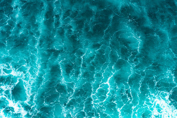 Texture Light blue surface of raging sea water with white foam and wave pattern