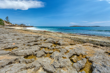 rocky beach in Antsiranana in low tide, Diego Suarez bay landscape, Madagascar beautiful pure nature with blue sky and water, Africa wilderness