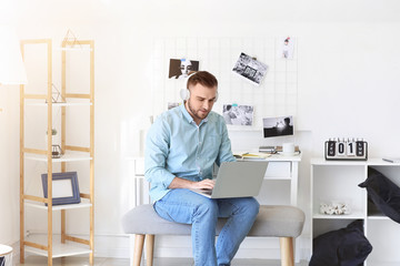 Young man with laptop working at home