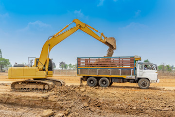 Excavator is dig and loading soil to the truck. Excavator is heavy construction equipment consisting of a boom, dipper, bucket and cab on a rotating platform.