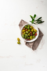 Olive pickled in white bowl on white surface