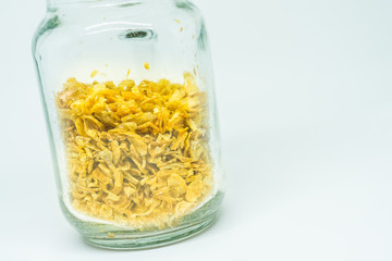 Deep-fried shallots on clear glass jar, isolated on white background.