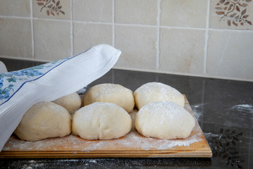 Bread dough rising on wooden cutting board