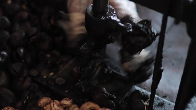 Burmese woman producing handmade cashews in traditional factory