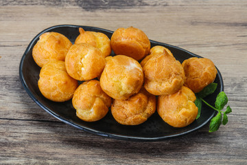Sweet tasty profiteroles heap in the bowl