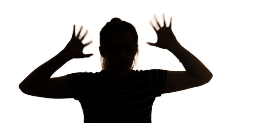 silhouette of a young woman with hands up in stress on a white isolated background, concept female emotions, fear and depression