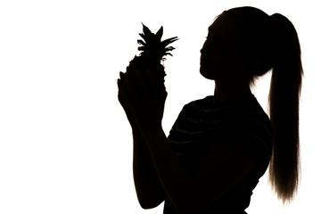 silhouette of woman figure with pineapple fruit in hands on white isolated background, concept vitamins and healthy food, female beauty