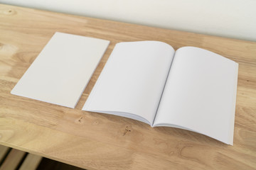 Blank catalog, magazines, book on wood background.