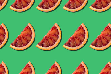 abstract citrus summer background. pattern of red orange slices on green background