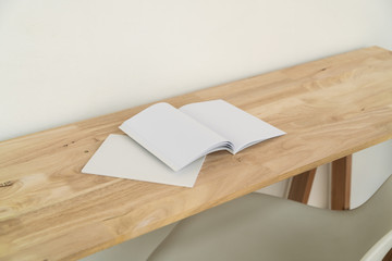 Blank catalog, magazines, book on wood background.