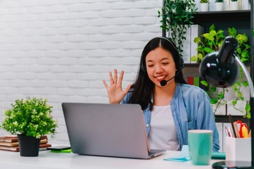 Asian business woman work from home with laptop computer on table with meeting online and video conferencing.Concept of social distancing to stop the spread disease of Corona virus.