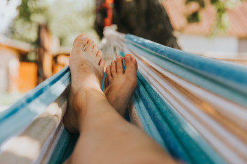 Relaxing in the hammock in the summer. Barefoot and carefree in the garden.  