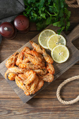 Shrimp on a wooden Board on a brown wooden table. Shrimp shrimps visor. Ecological seafood. Top view with space for text	
