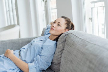Young woman relaxing at home daydreaming