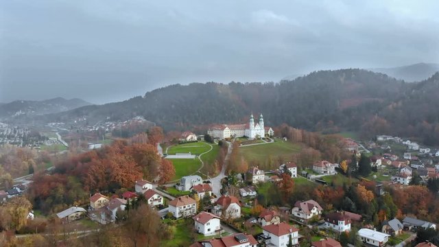 Wide angle dolly in drone shot of the city of Celje, Jozefov Hrib/Saint Joseph's hill and the beautiful buildings/houses during the day