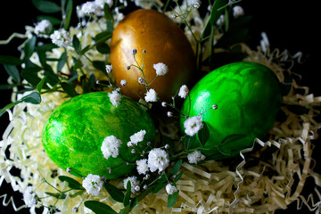 Birds paper nest with eggs decorated with flowers and leaves isolated on black background. happy easter. easter greeting card