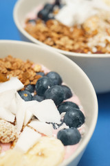 Handmade Bowl healthy tasty breakfast of yogurt, smoothie with granola, nuts, bananas and berries