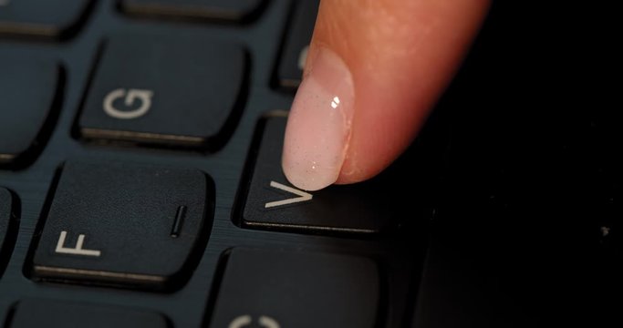 Pushing V button on the black keyboard. English letters. Used Macro lens and slow-mo.