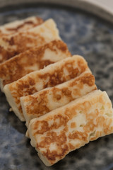 Pieces of fried Halloumi cheese on a gray ceramic plate