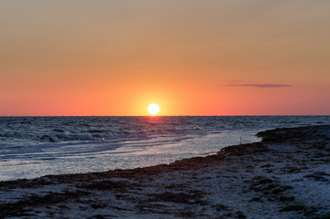 sea with waves and big bright sun over the horizon
