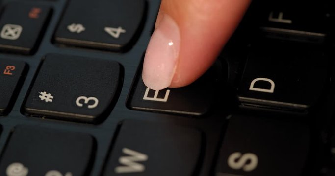Pushing E button on the black keyboard. English letters. Used Macro lens and slow-mo.