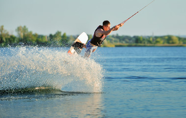 the guy is riding a wakeboard on the river. Active and Extreme Sports