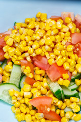 Corn salad, tomato and cucumber with olive oil. Food is proper nutrition. Vegetarian food