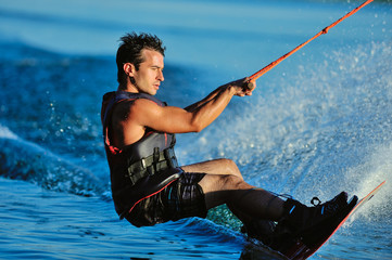 the guy is riding a wakeboard on the river. Active and Extreme Sports