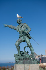 Fototapeta na wymiar Statue of the corsair Surcouf in Saint Malo with a gull on its head, France