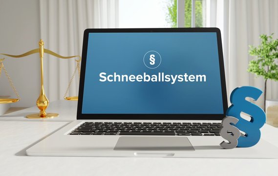 Schneeballsystem &ndash; Recht, Gesetz, Internet. Laptop im B&uuml;ro mit Begriff auf dem Monitor. Paragraf und Waage.