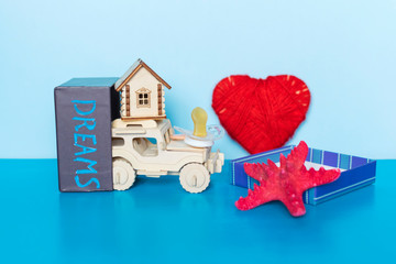 Word Dreams written on gift box, heart, car, house, starfish and pacifier on the blue background.