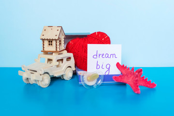 Words  Dream Big, heart, car, house, starfish and pacifier on the blue background.