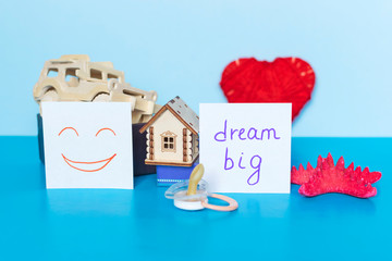 Words  Dream Big, heart, car, house, starfish and pacifier on the blue background.