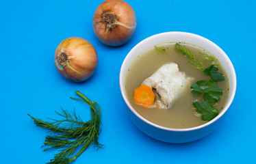Traditional fish soup. Blue background. Fish soup is a food made by combining fish or seafood with vegetables and stock