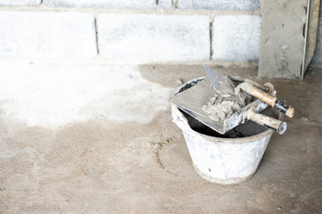 Cement in the tank with plastering the house wall on the construction site