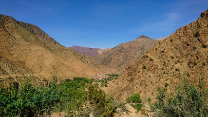 View of the Ourika Valley and a small village hidden between the mountains. Atlas mountains on a sunny day.
