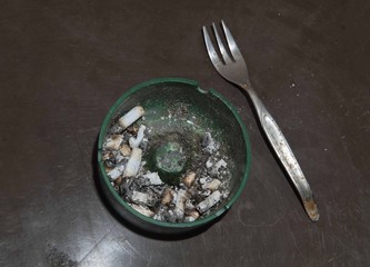 ashtray full of unlit cigarettes and fork