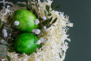 Happy easter. easter greeting card. Easter decoration with nest, eggs and spring flowers on dark backround.
