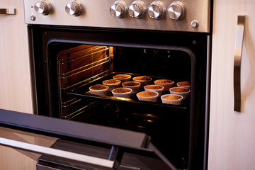 Baked cupcakes in an open oven close-up.