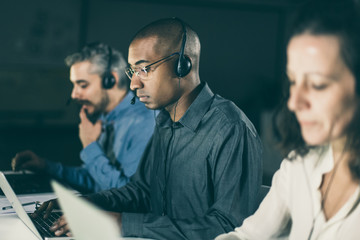 Thoughtful call center operators during working process. Confident client support team at...