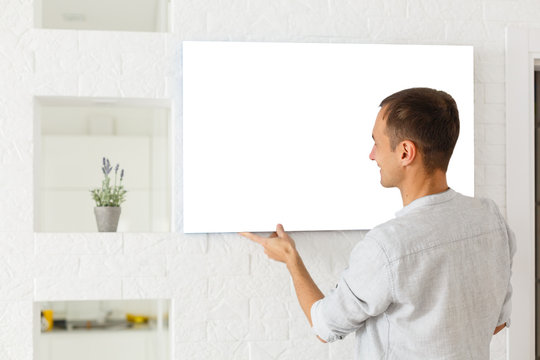 man holds canvas in the interior