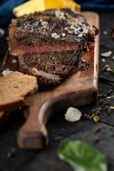 Sliced meat barbecue served with bread slices on a wooden board