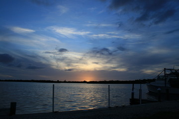 Fototapeta na wymiar Boat Moored On River Against Sky During Sunset