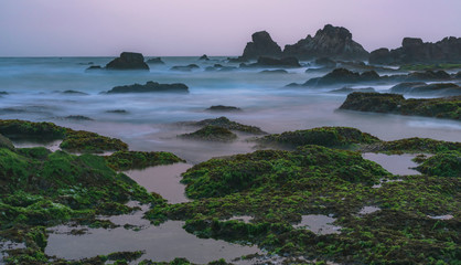 Evening scene with rocks in indian ocean taken using long exposure. Undiscovered location in Banten, Java, Indonesia