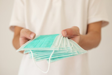 Man hold surgical face mask on hands for COVID-19 corona virus prevention concept
