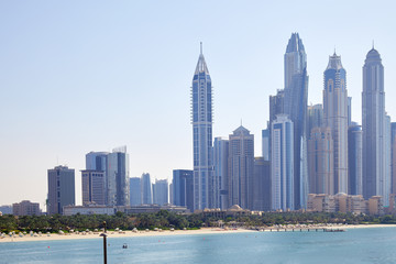 Dubai Marina skyscrapers with sea and beach in a sunny day, clear blue sky in Dubai