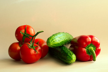 red pepper, tomatoes, red paprika and cucumber on a pastel pink background. Set of seasonal vegetables. The concept of a healthy diet