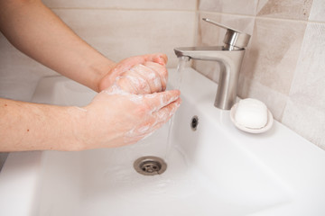 woman picks up liquid soap in her hands to wash. hand washing as protection against coronavirus infection.
