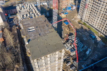 Aerial high top drone view. Pouring cement on the floors of residential multi-story building under...