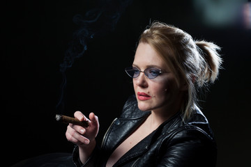 Woman with a cigar. The beautiful blonde. Black background